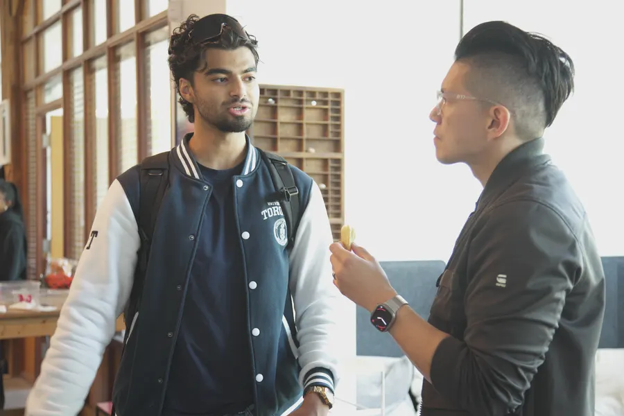 Two builders standing and talking, one mid-sentence.